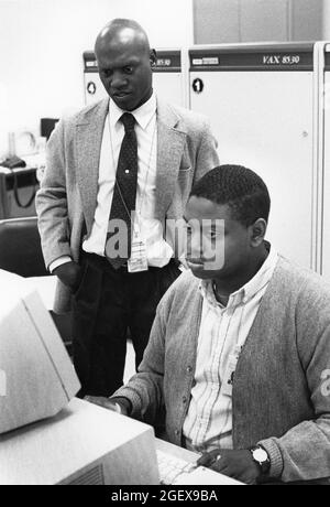 Austin Texas USA, 1990: Les employés entrent des données dans un terminal d'ordinateur tandis que le superviseur observe dans une installation de traitement des données du recensement des États-Unis pendant le compte décennal des personnes vivant dans le pays. ©Bob Daemmrich Banque D'Images