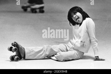 Luling, Texas États-Unis, vers 1988: Jeune fille fait un visage drôle après tomber pendant le patinage à roulettes. ©Bob Daemmrich Banque D'Images