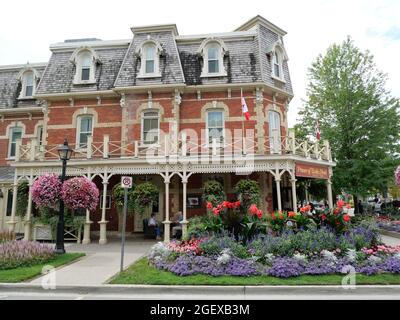 Hôtel victorien ancien de Niagara-on-the-Lake, Ontario, décoré de fleurs colorées dans la rue en été. Banque D'Images