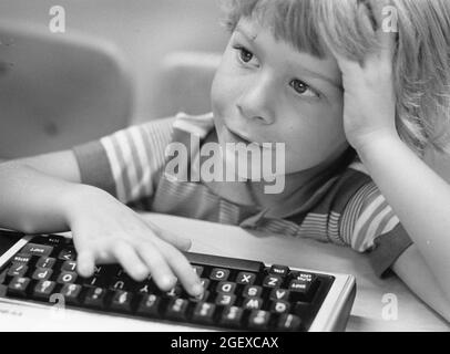 Austin Texas USA, vers 1994: Anglo male maternelle élève utilise un doigt pour taper sur le clavier pendant la classe d'ordinateur. ©Bob Daemmrich Banque D'Images