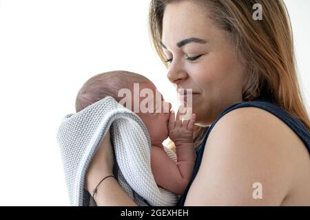 Maman tient une jeune fille qui pleure dans les bras, un portrait doux avec un petit enfant. Banque D'Images