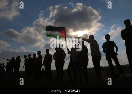 Gaza, Palestine. 21 août 2021. Un manifestant palestinien agité un drapeau lors d'une manifestation le long de la clôture avec Israël. Crédit : SOPA Images Limited/Alamy Live News Banque D'Images