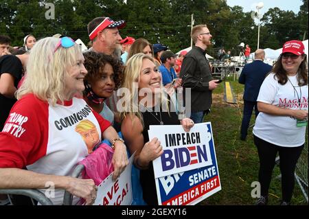 Cullman, Alabama, États-Unis. 21 août 2021. L'ancien président Donald Trump organise un rassemblement dans le nord de l'Alabama, s'adressant à des milliers de partisans dans un champ baigné de pluie et de boue.en photo : la députée de Géorgie Marjorie Taylor Green détient un signe d'impeachment Biden alors qu'elle accueille la foule et pose pour des photos. (Image de crédit : © Robin Rayne/ZUMA Press Wire) Banque D'Images