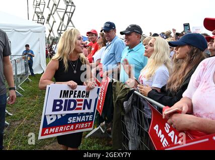 Cullman, Alabama, États-Unis. 21 août 2021. L'ancien président Donald Trump organise un rassemblement dans le nord de l'Alabama, s'adressant à des milliers de partisans dans un champ baigné de pluie et de boue.en photo : la députée de Géorgie Marjorie Taylor Green détient un signe d'impeachment Biden alors qu'elle accueille la foule et pose pour des photos. (Image de crédit : © Robin Rayne/ZUMA Press Wire) Banque D'Images