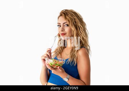 La jeune femme est en train de manger de la salade pour un corps en forme et une vie saine. Photo de haute qualité Banque D'Images