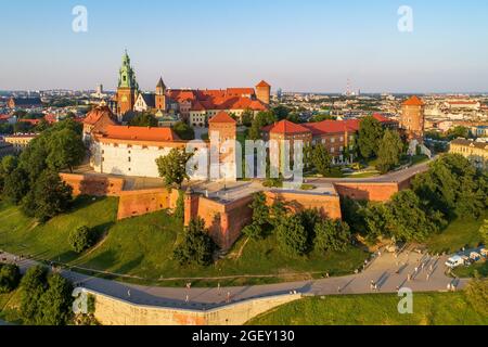 Cracovie, Pologne. Château royal et cathédrale historiques de Wawel. Vue aérienne au coucher du soleil en été. Parc, promenades et personnes à pied Banque D'Images