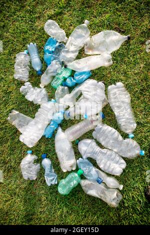 Signe d'incivilité utilisé bouteilles en plastique abandonnées dans un pré Banque D'Images