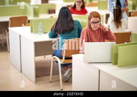 Une étudiante travaillant sur un ordinateur portable lors d'une conférence dans une salle de classe Banque D'Images