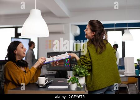 Collègues heureux parlant de montage de film créatif regarder des idées de production de film travailler dans le bureau de démarrage avec deux moniteurs. Projet d'édition vidéo pour femmes dans les logiciels de post-production Banque D'Images