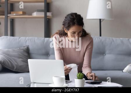 Les femmes sérieuses garde une facture papier calculer les dépenses rend compte Banque D'Images