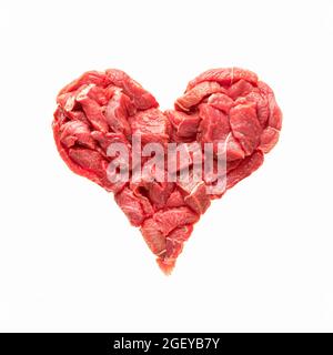 le coeur est fait à partir de viande crue isolat. le boeuf en forme de coeur, symbolise la maladie de coeur, la suralimentation, la cuisine ou l'industrie de la viande, ainsi que Banque D'Images