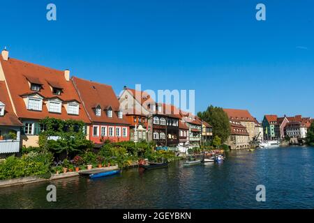 Vue pittoresque sur les bâtiments médiévaux le long de la rivière Regnitz avec la vieille barge, les bateaux amarrés et sur la rive de la rivière, Bamberg Allemagne Banque D'Images