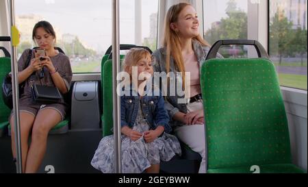 Promenades en famille dans les transports en commun, femme avec petite fille s'asseoir ensemble et regarder le tram de fenêtre Banque D'Images
