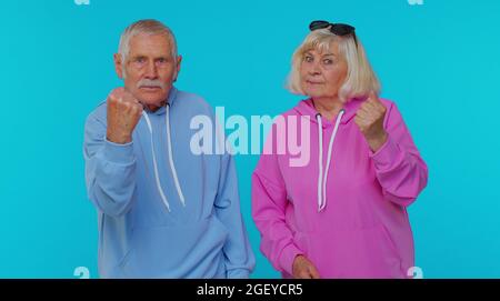 Une femme âgée agressive granny avec l'homme grand-père essayant de se battre à la caméra, secouant la poing, la boxe Banque D'Images