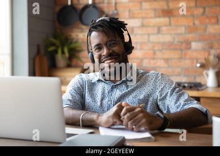 Bon élève de course mixte dans le casque satisfait de l'éducation à distance Banque D'Images