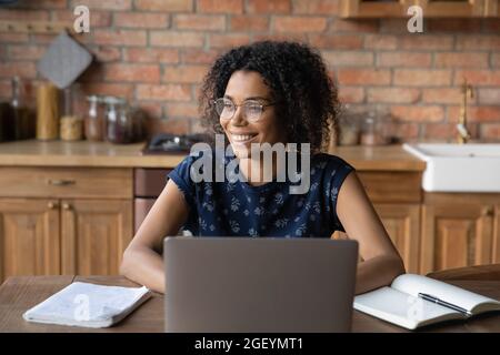 Joyeux Afro American distance professionnel dans les lunettes de travail à l'ordinateur portable Banque D'Images