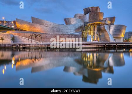 BILBAO, ESPAGNE - 10 juillet 2021 : le célèbre musée Guggenheim se reflète dans la rivière Nervion à l'aube Banque D'Images