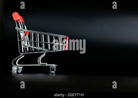 Panier vide sur fond noir avec espace de copie, shopping et concept de vendredi noir. Banque D'Images