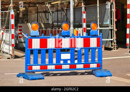 Barrière de chantier à rayures bleues, rouges et blanches avec travaux de construction en arrière-plan Banque D'Images