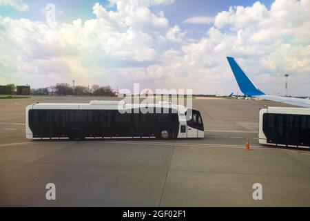 Aile d'avion et bus spécial pour déplacer les passagers d'un avion à l'autre terminal. Banque D'Images