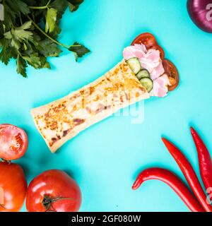 Cuisine de rue. Shawarma ou viande en pain pita sur fond vert vif. Banque D'Images