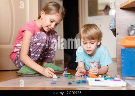 Russie, Moscou, octobre 2020 - deux petits enfants heureux un garçon de quatre ans et une fille de sept ans frères et sœurs ou amis à la maison ensemble Banque D'Images