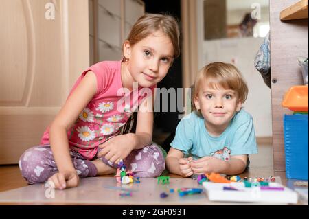 Russie, Moscou, octobre 2020 - deux petits enfants heureux un garçon de quatre ans et une fille de sept ans frères et sœurs ou amis à la maison ensemble Banque D'Images