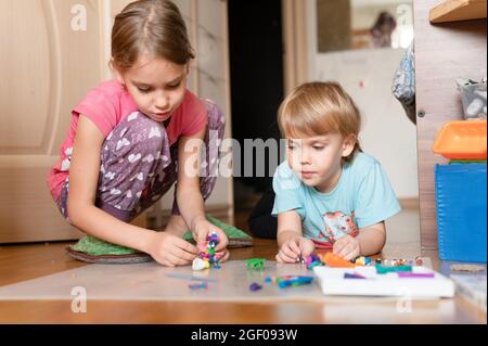 Russie, Moscou, octobre 2020 - deux petits enfants heureux un garçon de quatre ans et une fille de sept ans frères et sœurs ou amis à la maison ensemble Banque D'Images