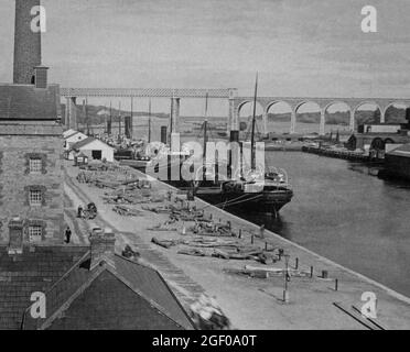 Une vue du début du XXe siècle de la navigation amarrée aux quais sur la rivière Boyne comme il coule à travers Drogheda sur la frontière des comtés Meath et Louth en Irlande. Au-delà peut être vu le viaduc de chemin de fer et le pont. Banque D'Images