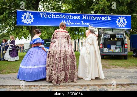 Schleswig, Allemagne. 22 août 2021. Un groupe de femmes en costumes historiques se tient sur le stand de l'Agence fédérale de secours technique lors du festival des citoyens à l'occasion du 75e anniversaire de l'État fédéral du Schleswig-Holstein sur les terrains du château de Gottorf. Credit: Gregor Fischer/dpa/Alay Live News Banque D'Images