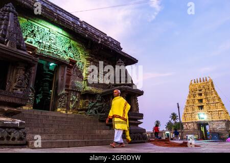 Belur, Karnataka, Inde : Temple Channakhava du XIIe siècle. Un prêtre hindou contourne au coucher du soleil le temple principal de Kesava. Banque D'Images