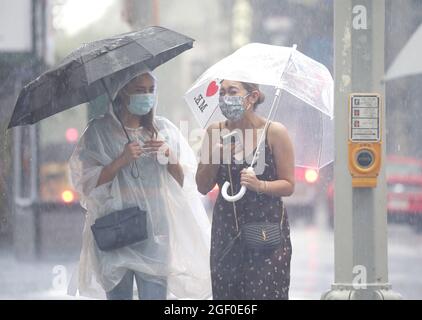 New York, États-Unis. 22 août 2021. Des piétons traversent Times Square en portant des parasols alors que la pluie tombe à New York le dimanche 22 août 2021. La tempête Henri s'est rétrogradée d'un ouragan ce matin continue à se rapprocher du nord-est avec des zones de New York et du New Jersey déjà en proie à des inondations. Photo de John Angelillo/UPI crédit: UPI/Alay Live News Banque D'Images