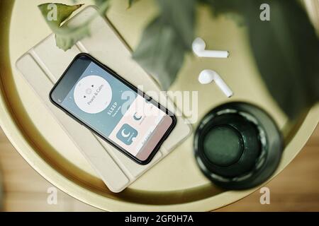 Vue de dessus vers le bas sur un smartphone avec application pour assistant de sommeil sur une table de chevet, espace de copie Banque D'Images