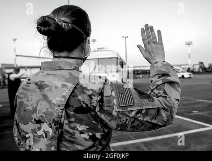 Un Airman de la Force aérienne des États-Unis fait la vague en tant que premier autobus des évacués afghans arrive au joint Processing Readiness Centre de la base aérienne de Ramstein, en Allemagne, le 20 août 2021. La base aérienne de Ramstein fournit un hébergement temporaire et sûr aux personnes évacuées d'Afghanistan dans le cadre de l'opération alliés refuge. Cette opération facilite l'évacuation rapide et sécuritaire des citoyens américains, des demandeurs de visa d'immigrant spécial et d'autres Afghans à risque de l'Afghanistan. PHOTO DE CRÉDIT: DOD US via American PhotoArchive Banque D'Images