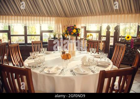 Décoration festive de style automnal avec numérotation des tables sur citrouilles dans la salle de banquet. Floristerie et décoration d'événements arrangements floraux. Banque D'Images