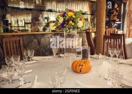 Décoration festive de style automnal avec numérotation des tables sur citrouilles dans la salle de banquet. Floristerie et décoration d'événements arrangements floraux. Banque D'Images