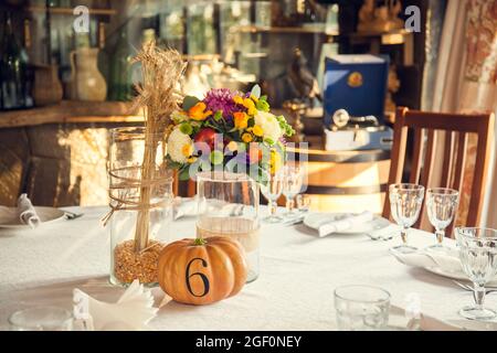 Décoration festive de style automnal avec numérotation des tables sur citrouilles dans la salle de banquet. Floristerie et décoration d'événements arrangements floraux. Banque D'Images