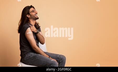 Un homme positif du Moyen-Orient assis sur une chaise, s'est vacciné Banque D'Images