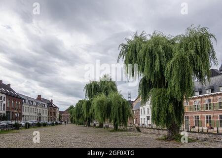 Gand, Flandre, Belgique - 30 juillet 2021 : Kinderrechtenplein (place des droits des enfants) le long de la rivière Lieve sous un paysage nuageux et pluvieux de gris. Vert Banque D'Images