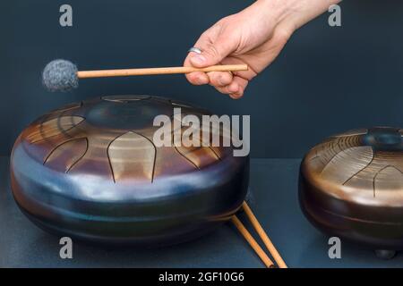 Timon en acier, tambour. Bol de chant, tambour en acier et pilons. Instrument pour la thérapie par ondes sonores et la méditation, la guérison. Banque D'Images