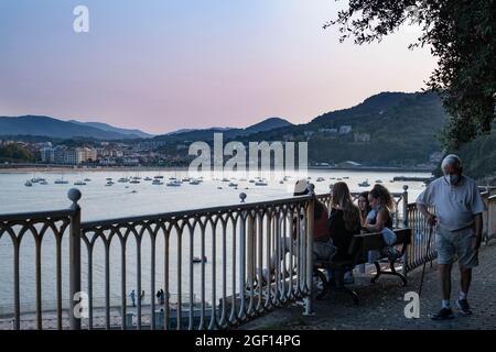 Personnes assises sur un banc d'observation de la baie de la Contxa à San Sebastian, Espagne Banque D'Images