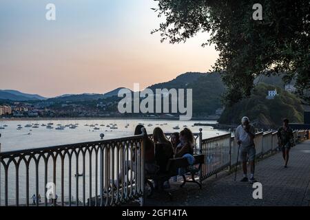 Personnes assises sur un banc d'observation de la baie de la Contxa à San Sebastian, Espagne Banque D'Images