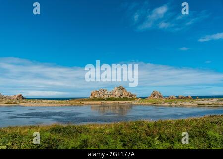 Une petite maison Castel Meur entre les rochers près de la mer à Plougrescant, France Banque D'Images