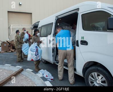 Les membres de la 379e Escadre expéditionnaire aérienne transportent des dons pour les évacués de l'Afghanistan dans un hangar dans la zone de responsabilité du CENTCOM, le 19 août 2021. Des citoyens afghans ont été évacués à bord d'un avion militaire à l'aéroport international Hamid Karzaï de Kaboul. (É.-U. Photo de la Force aérienne par Airman 1ère classe Kylie Barrow) Banque D'Images