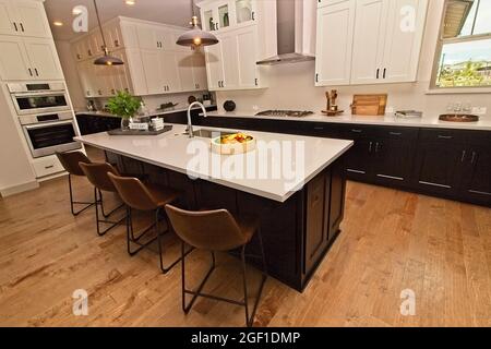 Cuisine avec tabourets en métal, îlot et Cabinetry sur mesure Banque D'Images