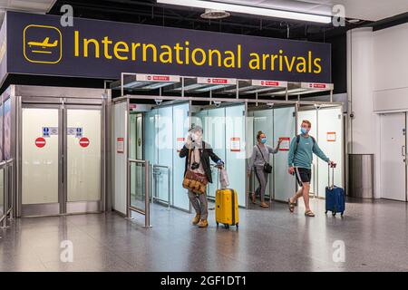 GATWICK, LONDRES, ROYAUME-UNI. 22 août 2021. Les passagers portant un masque arrivent au terminal international du Nord à l'aéroport de Gatwick. Le gouvernement a récemment renoncé à la quarantaine pour les passagers entièrement vaccinés arrivant des pays de la liste ambre. Credit amer ghazzal/Alamy Live News Banque D'Images