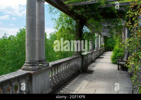 Une passerelle couverte d'arbres et de vignes dans le Hill Garden et Pergola, Hampstead Heath, Londres, Royaume-Uni. Un banc vide se tient sur la terrasse. Banque D'Images