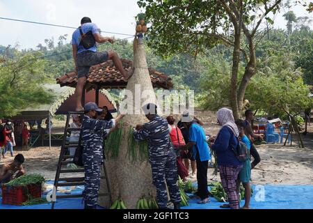 Les gens organisent des légumes pour faire le tumpeng sayur (cône de légumes) pour la cérémonie de la sedekah bumi (action de grâce javanaise) à la plage de sanggar Banque D'Images