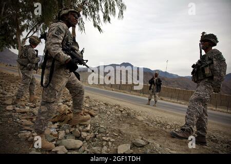 SPC de l'armée américaine. Frederick Tolon, centre, 27, de Crawford, Mils; SPC. Jonathan Betancourt, à gauche, 22 ans, de Kerman, en Californie, et le sergent d'état-major. Mike Cruz assure la sécurité à l'extérieur de la base de l'opération Forward Joyce, en Afghanistan, au cours d'une cérémonie de rupture du complexe sportif Ghulam Mohammad le 12 décembre 2009. Tous les soldats sont des membres du détachement de sécurité personnelle, du quartier général et de la Compagnie des Headquartes, 1er Bataillon, 32e Régiment d'infanterie, équipe de combat de la 3e Brigade, 10e Division de montagne. Banque D'Images