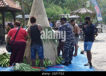 Les gens organisent des légumes pour faire le tumpeng sayur (cône de légumes) pour la cérémonie de la sedekah bumi (action de grâce javanaise) à la plage de sanggar Banque D'Images